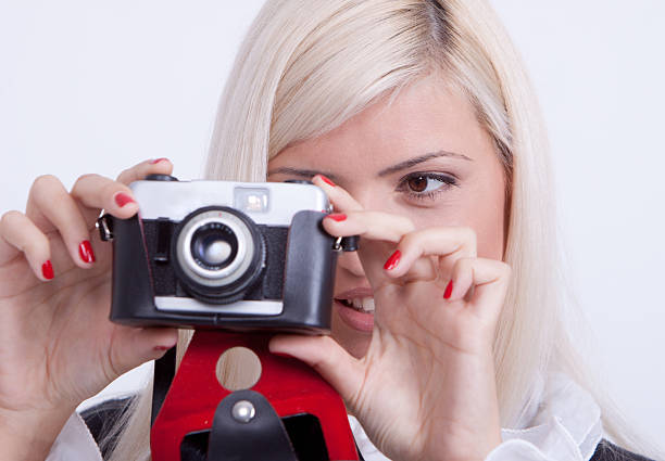 istock Blonde woman photographing over white background 519622917