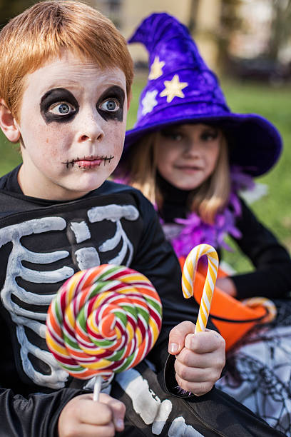 istock Halloween. Skeleton and witch holding colorful candies 519623861
