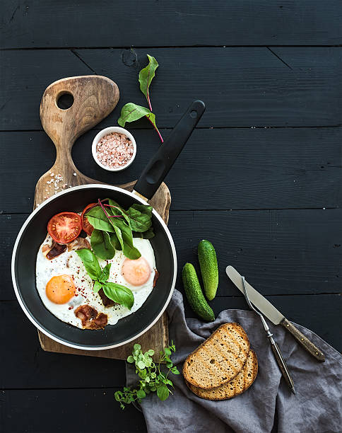 istock Pan of fried eggs, bacon, tomatoes with bread, mangold and 519624230