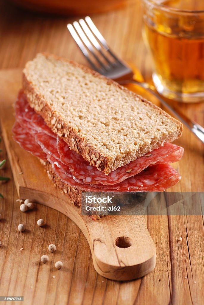 bread and salami bread and salami on wooden chopping board Appetizer Stock Photo