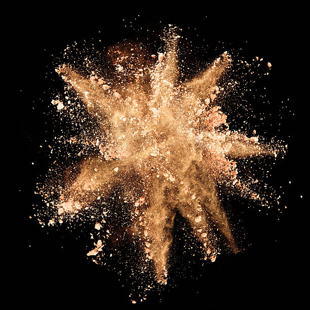 istock Explosion of brown powder on black background 519649800