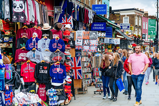 London, Uk - September 4, 2015: Shoppers browsing the Gift Shops in Camden Town, London. Gift shops selling t-shirts, souvenirs, sunglasses and flags. Camden Town, district of Inner London, one of the most popular places in London among locals and tourists. 