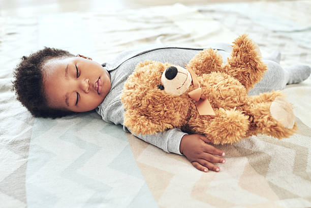 They're out for the count Shot of a little baby boy sleeping on the floor with his teddy bear teddy bear photos stock pictures, royalty-free photos & images