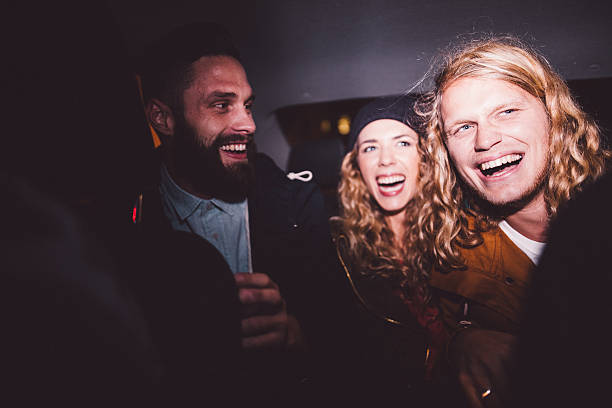 Hipster friends having fun inside a car at night Three hipster young adult friends smiling and partying inside a car at night hipster car stock pictures, royalty-free photos & images