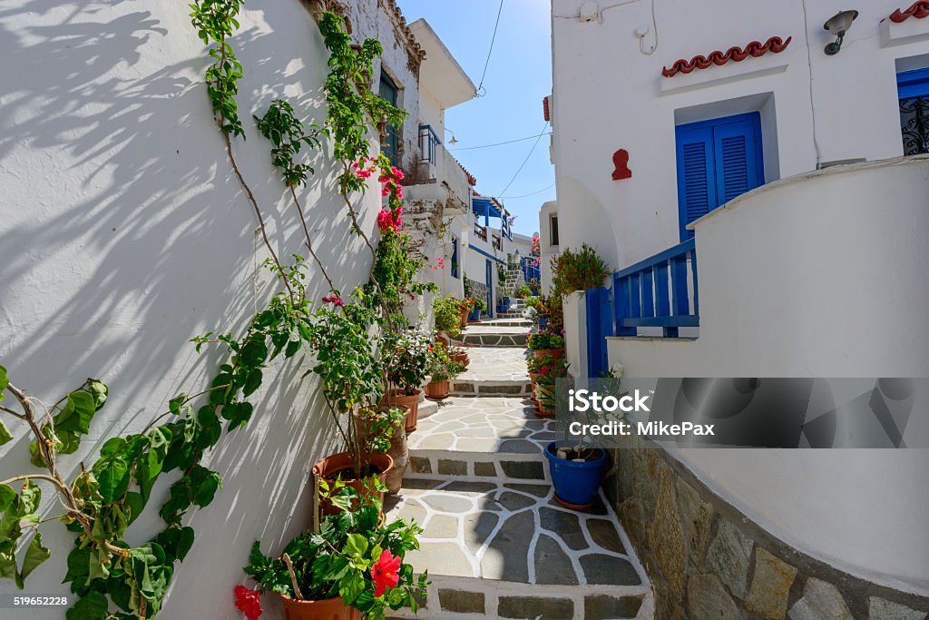 Stone slated alley with limewashed houses Typical stone slated alley with limewashed houses and bougainvilleas in Kythnos, Greece Greece Stock Photo
