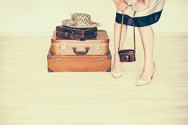 Woman stands beside a suitcase