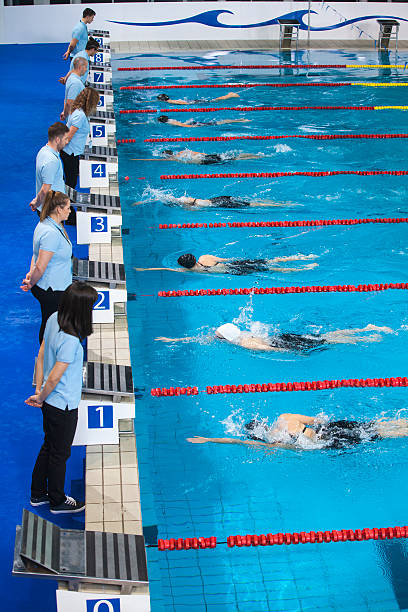 istock Coach standing at swimming starting block 519659754