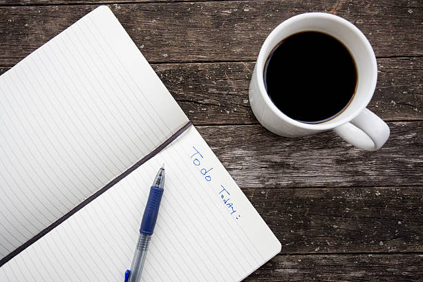 istock notebook pen and cup of coffee in wood table 519660059
