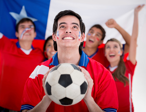 Happy group of football fans cheering for Chile
