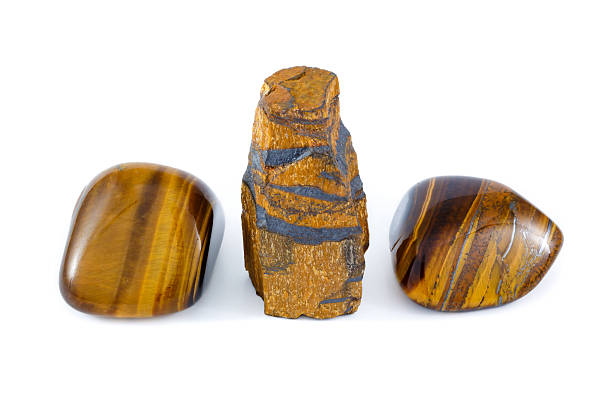 Tiger's eye rough and tumbled gemstone close up white background studio. Semi precious stone.