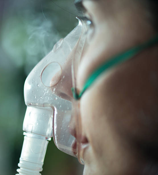 vista di un primo piano di una donna con maschera nebulizzatore - bombola di ossigeno foto e immagini stock