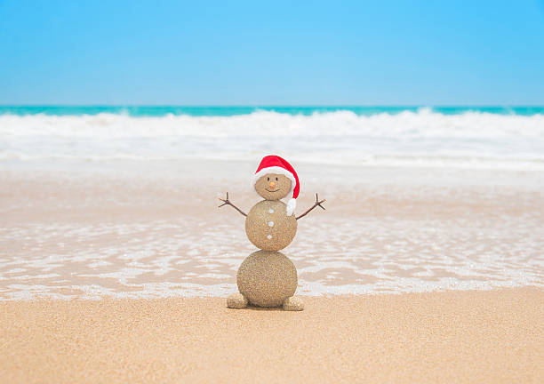 istock Christmas sandy snowman in santa hat at tropical beach 519661663