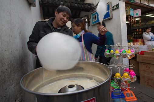 Shanghai, China - April 7, 2013: Unidentified man making sugar-candy floss in a local shops in Qibao. Ancient Town with ancient water townships, Shanghai 2013.