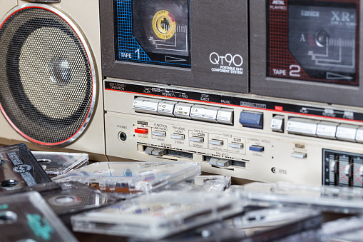 Zhytomyr, Ukraine, 24 March 2016. Cassette tape recorder Sharp model QT-90ZG with cassettes. The tape recorder was made in Japan for export. Cassettes are scattered on the table near the tape recorder.