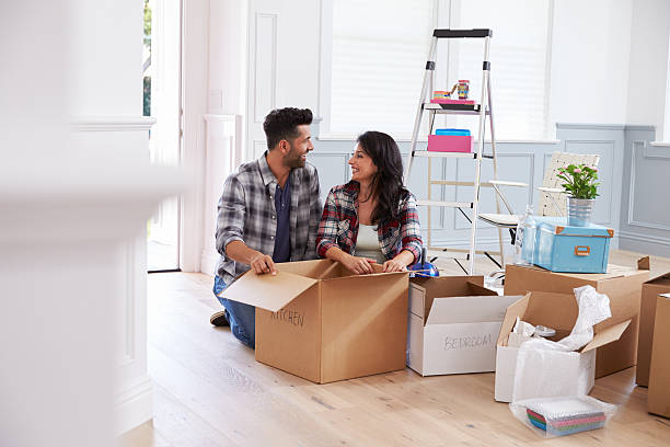 istock Hispanic Couple Moving Into New Home And Unpacking Boxes 519663918