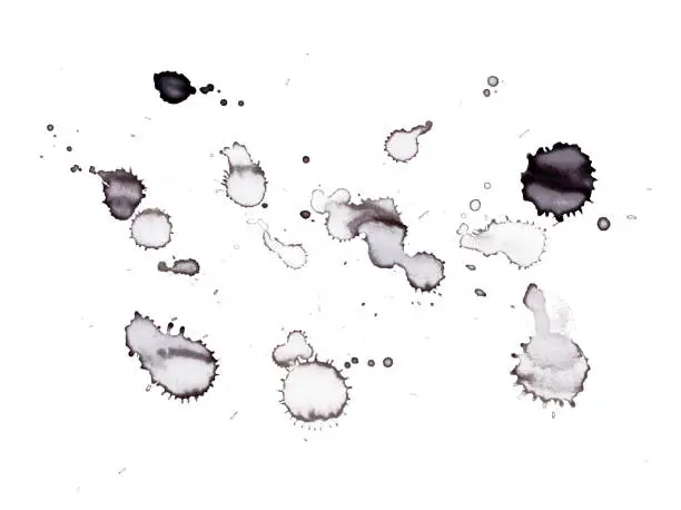 Black ink and paint drops splattered on a white background.