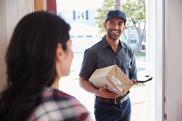 istock Woman Receiving Package From Courier At Home 519664180