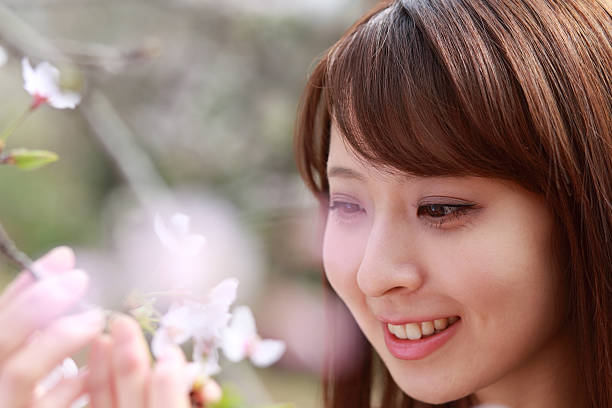 istock smiling woman with cherry blossoms,sakura 519664280