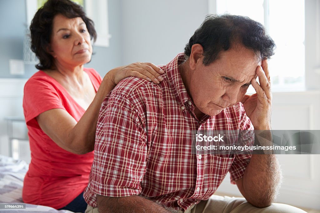 Mujer Senior con esposo reconfortante que sufren demencia - Foto de stock de Etnia Latinoamericana libre de derechos