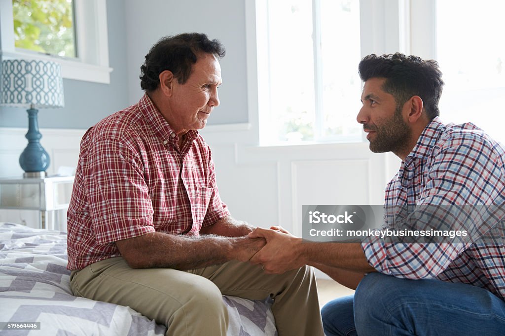 Adult Son Comforting Father Suffering With Dementia Senior Adult Stock Photo