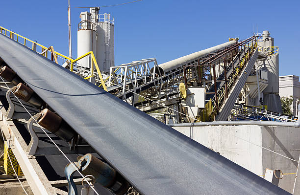 Manufacturing Equipment Multiple conveyor belts are used at a processing site. large machine stock pictures, royalty-free photos & images