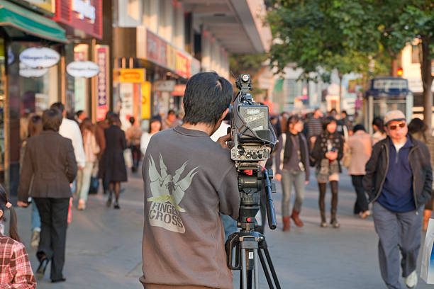 Hong Kong, Hong Kong S.A.R. - December 23, 2008: TV Reporter shooting street scene in Kowloon, Hong Kong. Kowloon is an urban area in Hong Kong comprising the Kowloon Peninsula and New Kowloon. It is located north of Hong Kong Island and has a population of more than 2 millions.