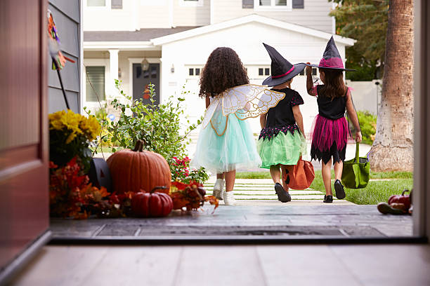 Three Children In Halloween Costumes Trick Or Treating Three Children In Halloween Costumes Trick Or Treating trick or treat photos stock pictures, royalty-free photos & images