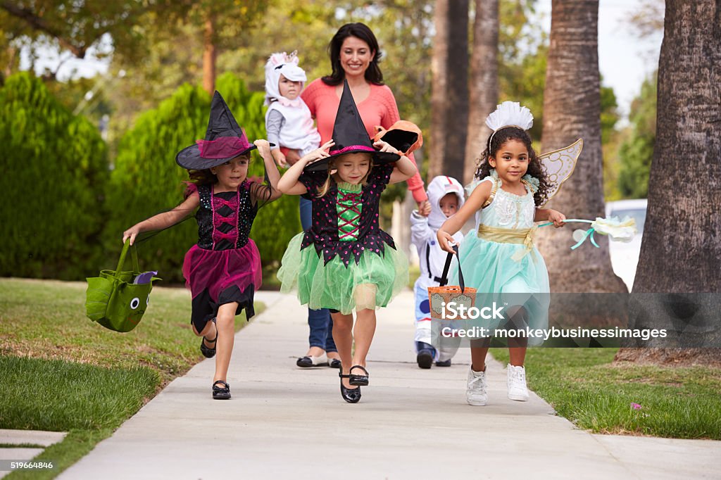 Parent Taking Children Trick Or Treating At Halloween Trick Or Treat Stock Photo
