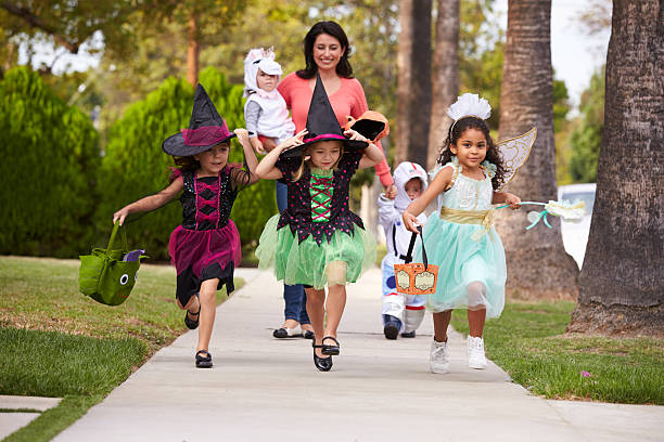 Parent Taking Children Trick Or Treating At Halloween Parent Taking Children Trick Or Treating At Halloween trick or treat photos stock pictures, royalty-free photos & images