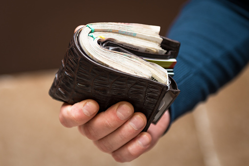 A man holds a purse with money