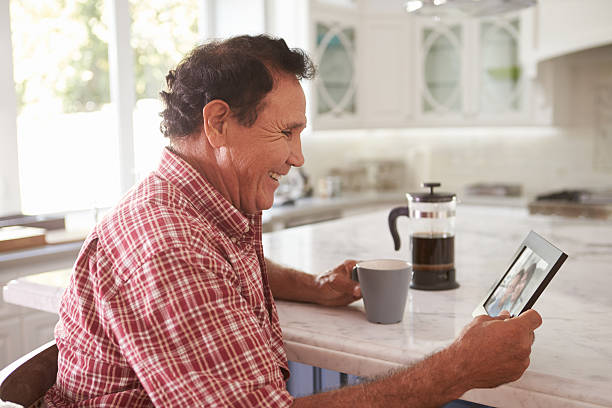 istock Senior Hispanic Man At Home Looking At Old Photograph 519665304