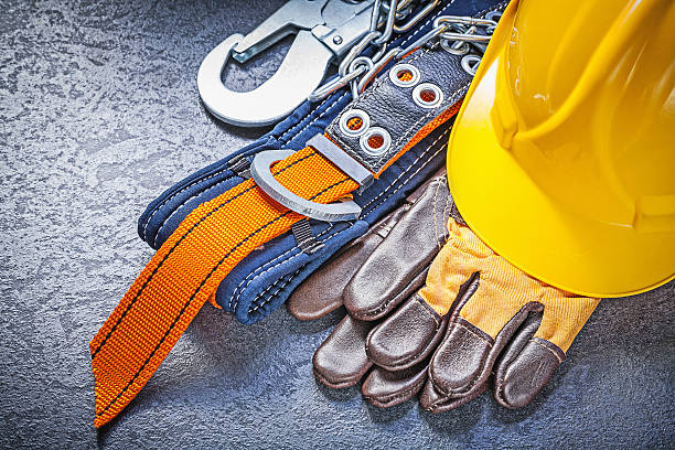 Construction safety harness protective gloves hard hat on black Construction safety harness protective gloves hard hat on black background maintenance concept. safety harness photos stock pictures, royalty-free photos & images