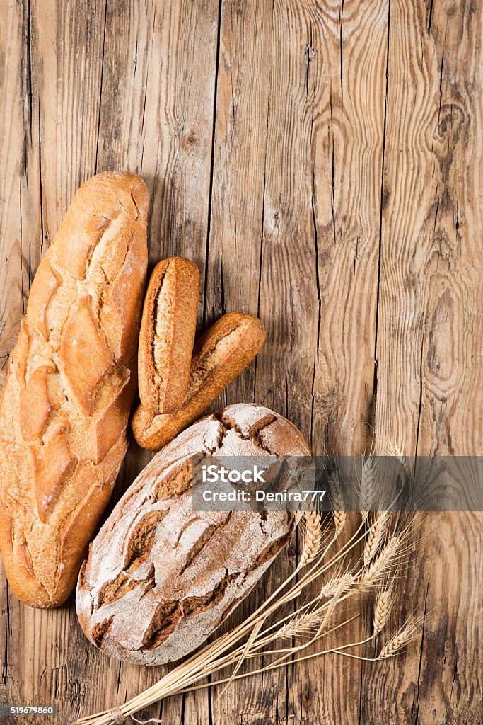 Bread view from above Top view of composition with bread and ears of wheat on wooden background with space. Above Stock Photo