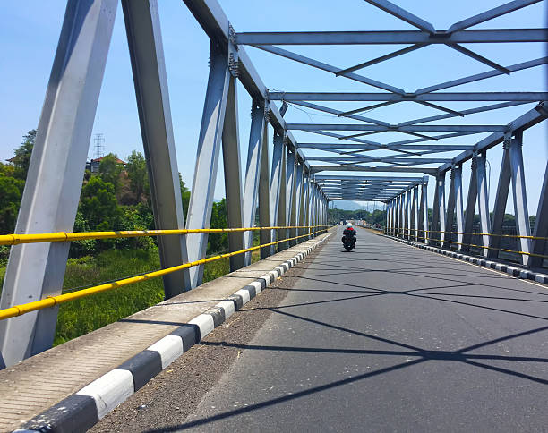 The highway and industrial bridge with the beautiful geometry of stripes, lights and shadows in the afternoon