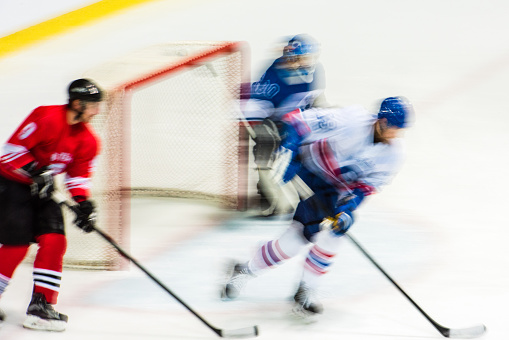 Ice hockey player playing ice hockey in ice hockey stadium, blurred motion.