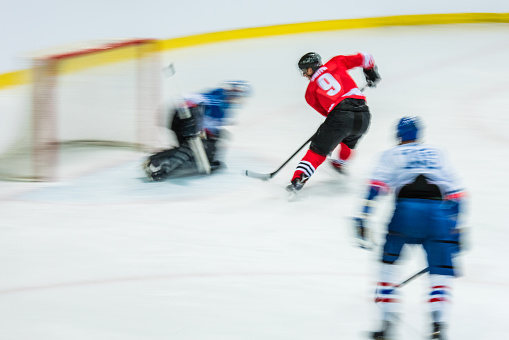 Ice hockey player playing ice hockey in ice hockey stadium, blurred motion.
