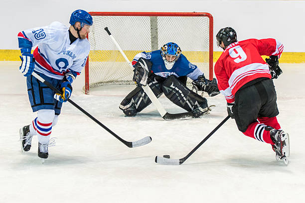 Men playing ice hockey Ice hockey goalkeeper trying to catch puck in ice hockey stadium. ice hockey stock pictures, royalty-free photos & images