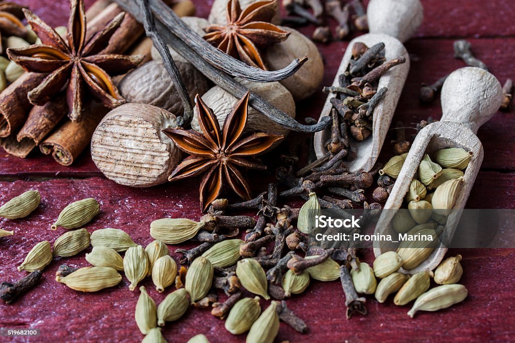 fragrant spices in wooden scoops fragrant mix of spices in wooden scoops Allspice Stock Photo