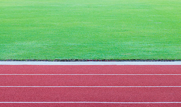 istock track running, red treadmill with green grass field, soft focus 519682152