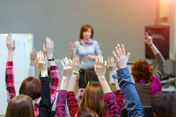 ativa os estudantes aumentar os braços para cima e pronta para responder perguntas dos professores - cheering arms raised women university - fotografias e filmes do acervo