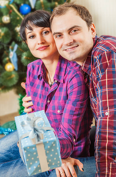 istock Happy couple with gift boxes under the christmas tree 519682659