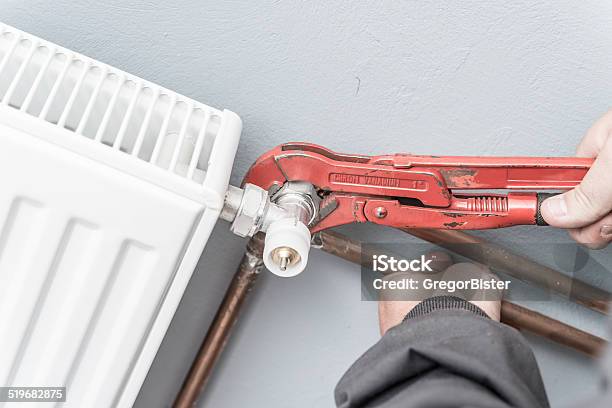 Man Fixing Radiator Stock Photo - Download Image Now - Adjustable, Adjustable Wrench, Adjusting