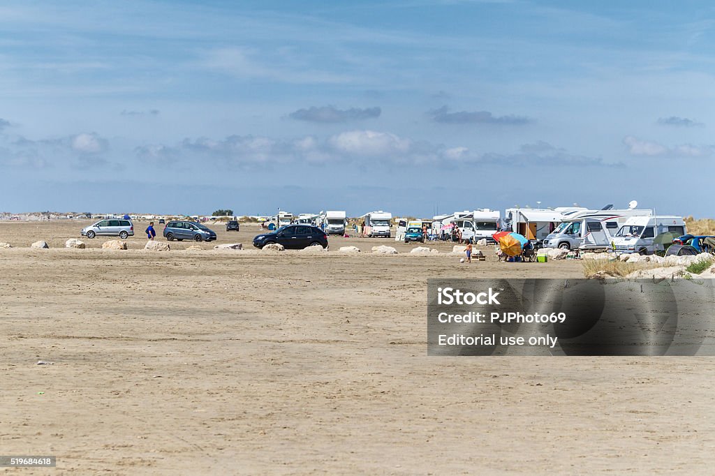 Piemanson Beach - Salin de Giraud Plage de Piemanson, France - August 28, 2015: Panoramic view of Plage de Piemanson near the Salin de Giraud (Camargue). Many people are on the beach where is permitted the free camping. Many caravans and motorhomes on the beach. This beach is a preferred place for nudists. Agriculture Stock Photo