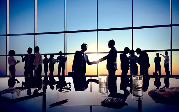 бизнесмен, handshaking вместе с их коллегами - silhouette handshake business customer стоковые фото и изображения
