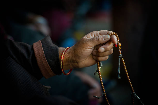 hände von einem tibetischen buddhistischen mit seinem gebetskette - tibetan buddhism stock-fotos und bilder