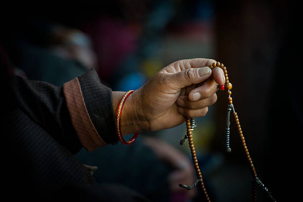 Hands of a Tibetan Buddhist with his prayer beads Hands of a Tibetan Buddhist cycles through his prayer beads while chanting. mantra stock pictures, royalty-free photos & images