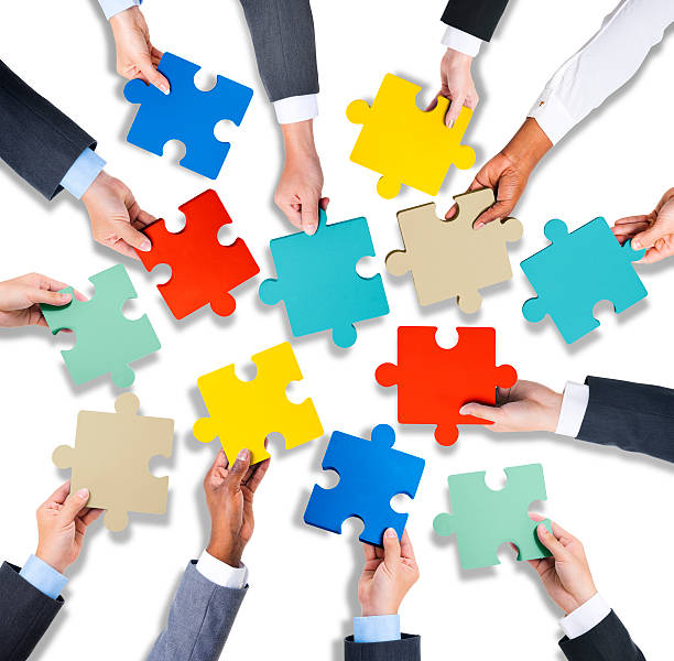 istock Group of Hands Holding Jigsaw Puzzle 519688559