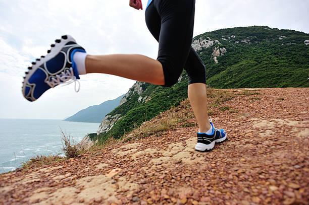 runner legs running on seaside mountain trail