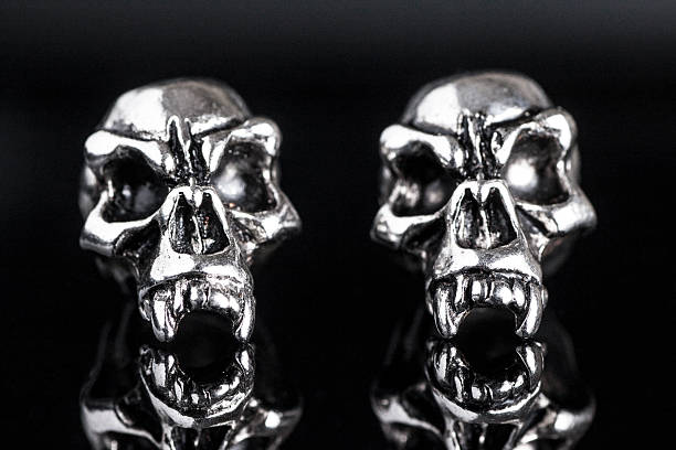 istock two metal skull on a black background 519690472