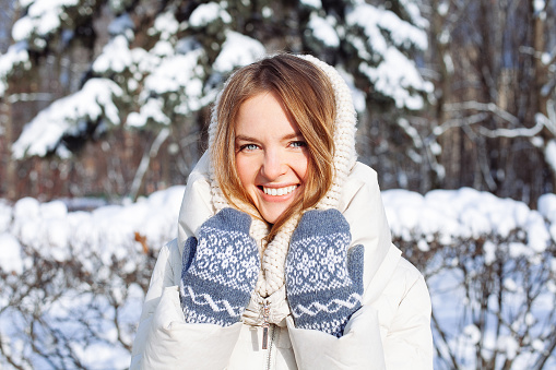 Beautiful winter portrait of young woman in the winter snowy scenery